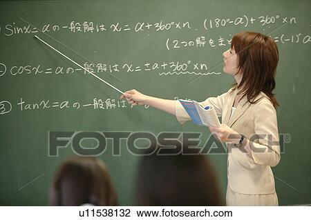 Stock Image - Female teacher teaching in classroom. Fotosearch