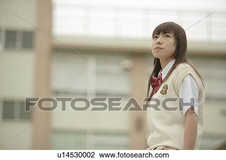 Stock Image - High school girl in schoolyard. Fotosearch