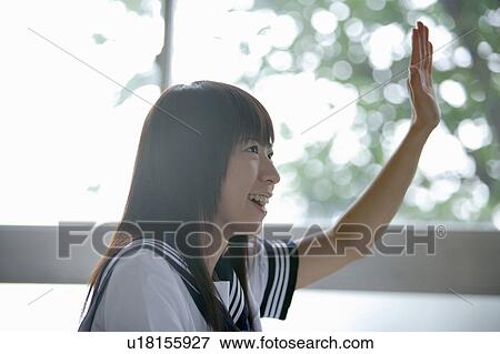 Stock Photo - High school girl raising hand in class. Fotosearch