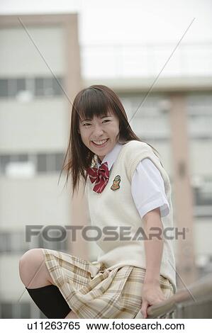 Stock Photography - High school girl sitting on railing and looking at camera. Fotosearch