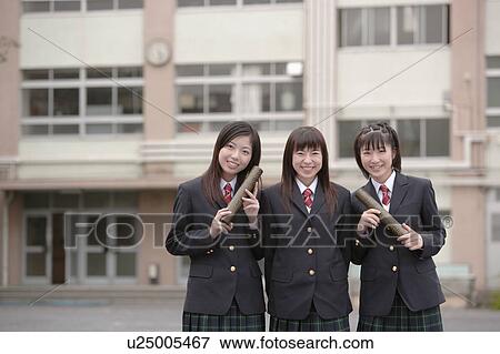 Stock Photo - Three high school girls holding graduation certificates. Fotosearch