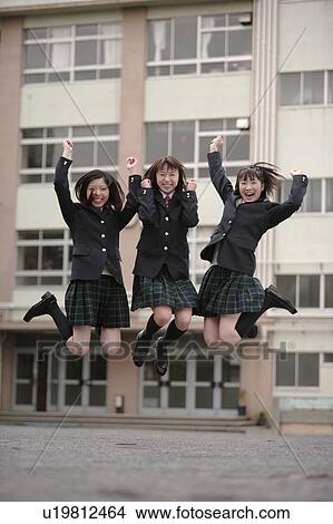 Picture - Three high school girls jumping in schoolyard. Fotosearch