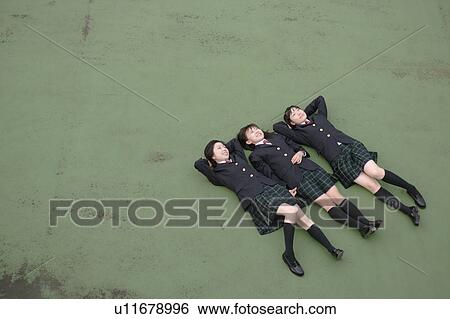 Stock Photograph - Three high school girls lying down. Fotosearch