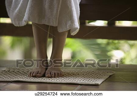 Picture - Feet of young woman on bath mat. Fotosearch