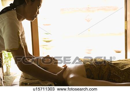 Stock Image - Young woman having neck massage. Fotosearch
