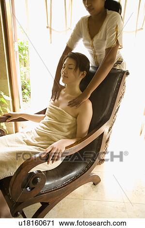 Stock Image - Young woman having shoulder massage. Fotosearch