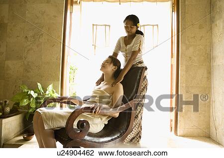 Stock Image - Young woman having shoulder massage. Fotosearch