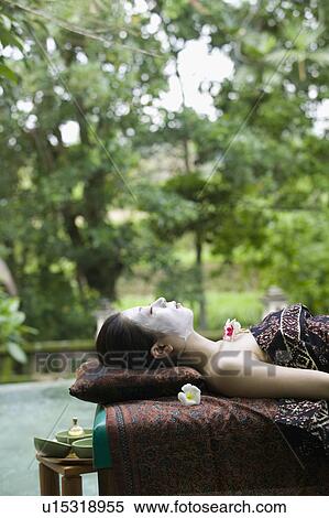 Stock Photography - Young woman lying down on massage table. Fotosearch