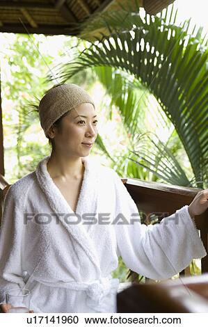 Stock Image - Young woman sitting on deck . Fotosearch
