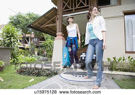 Stock Photo - Two young women carrying suitcases. Fotosearch