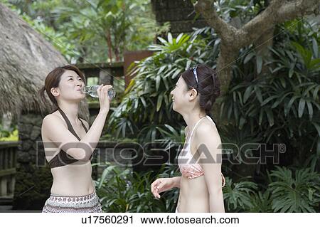 Stock Image - Two young women drinking water. Fotosearch