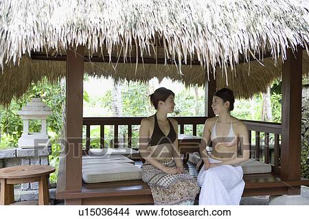 Two young women sitting under gazebo View Large Photo Image Picture - Two young women sitting under gazebo. Fotosearch