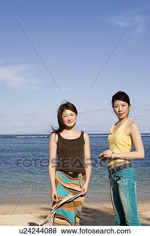 Two young women standing on beach View Large Photo Image Stock Photo - Two young women standing on beach. Fotosearch