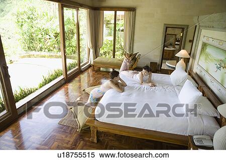 Stock Photography - Two young women talking in bedroom. Fotosearch