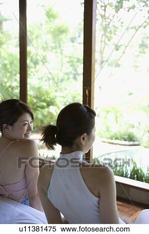Two young women talking View Large Photo Image Stock Photography - Two young women talking. Fotosearch