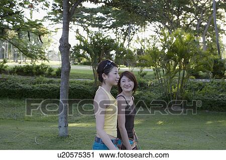 Two young women walking View Large Photo Image Stock Image - Two young women walking. Fotosearch