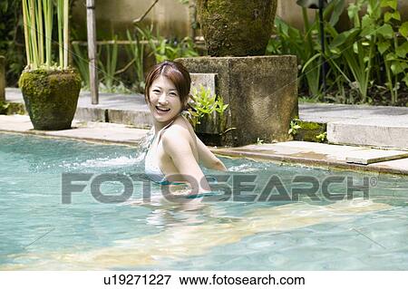 Stock Photo - Young woman in swimming pool. Fotosearch
