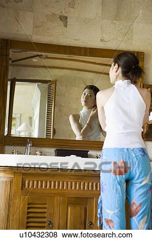 Young woman looking into mirror View Large Photo Image Stock Photo - Young woman looking into mirror. Fotosearch