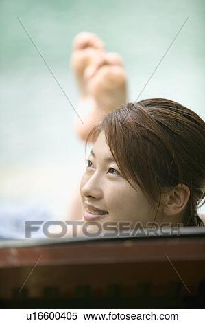 Stock Photography - Young woman on deck chair. Fotosearch