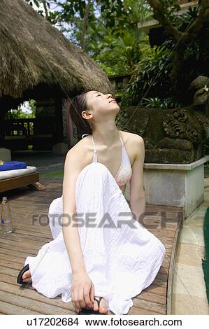 Picture - Young woman sitting on deck. Fotosearch