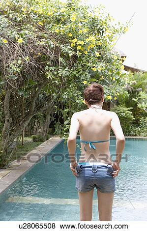 Young woman undressing by pool View Large Photo Image Stock Photo - Young woman undressing by pool. Fotosearch