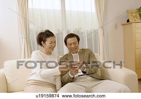 Picture - Mature couple looking at mobile phone. Fotosearch