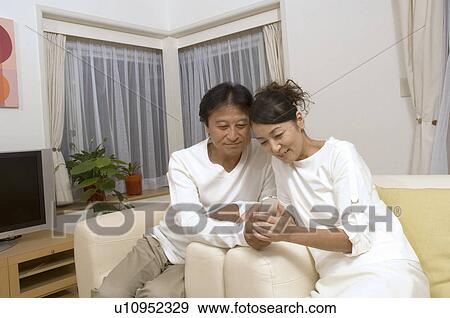 Mature couple looking at mobile phone View Large Photo Image Stock Photo - Mature couple looking at mobile phone. Fotosearch