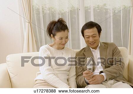 Stock Photo - Mature couple looking at mobile phone. Fotosearch
