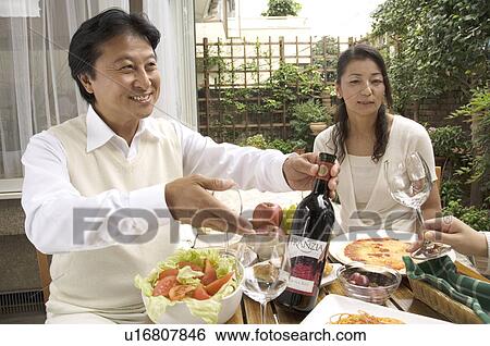 Stock Photograph - Mature couple sitting at table outside. Fotosearch