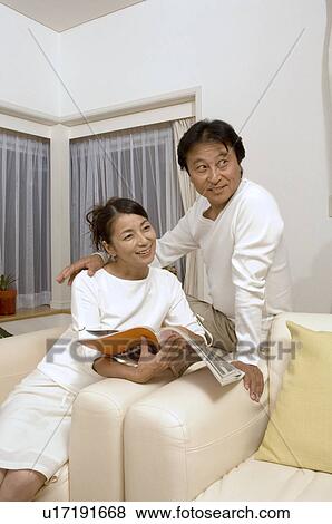 Mature couple sitting with magazine View Large Photo Image Stock Photo - Mature couple sitting with magazine. Fotosearch