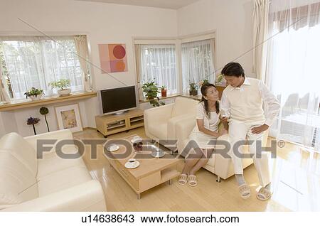 Stock Image - Mature couple talking in living room. Fotosearch
