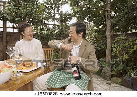 Mature man opening bottle of wine View Large Photo Image Stock Photo - Mature man opening bottle of wine. Fotosearch