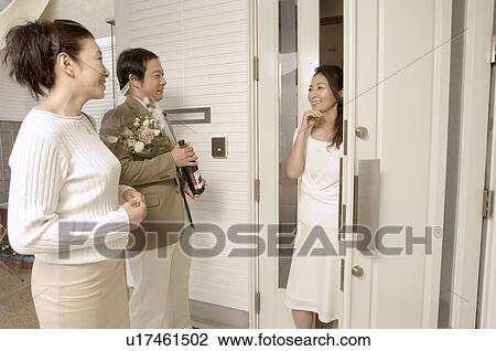 Mature woman greeting mature couple at front door View Large Photo Image Stock Image - Mature woman greeting mature couple at front door. Fotosearch