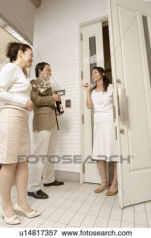 Mature woman greeting mature couple at front door View Large Photo Image Stock Photo - Mature woman greeting mature couple at front door. Fotosearch
