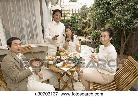 Two mature couples having wine outside View Large Photo Image Stock Photo - Two mature couples having wine outside. Fotosearch