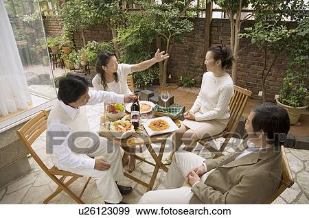 Two mature couples sitting at table outside View Large Photo Image Stock Photo - Two mature couples sitting at table outside. Fotosearch