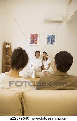 Two mature couples talking in living room View Large Photo Image Stock Image - Two mature couples talking in living room. Fotosearch