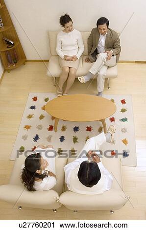 Stock Image - Two mature couples talking in living room. Fotosearch