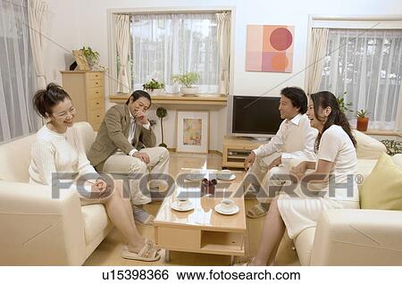 Stock Photograph - Two mature couples talking in living room. Fotosearch