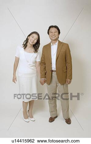 Stock Image - Mature couple holding hands. Fotosearch