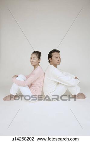 Mature couple sitting back to back, hugging knees View Large Photo Image Stock Image - Mature couple sitting back to back, hugging knees. Fotosearch