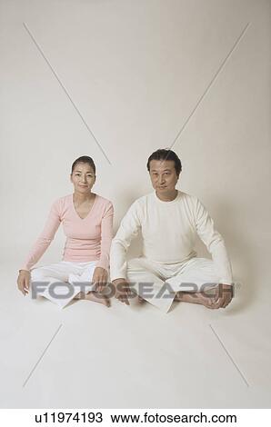 Mature couple sitting cross-legged View Large Photo Image Stock Image - Mature couple sitting cross-legged. Fotosearch