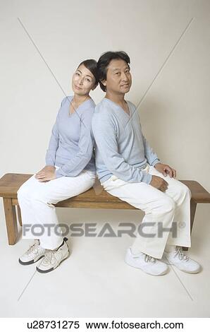 Mature couple sitting on bench back to back View Large Photo Image Stock Photography - Mature couple sitting on bench back to back. Fotosearch