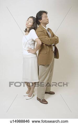 Stock Photograph - Mature couple standing back to back. Fotosearch