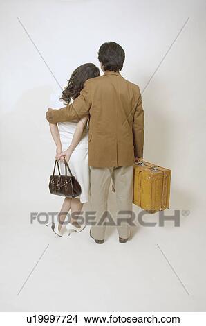 Picture - Mature couple standing with suitcase and bag. Fotosearch