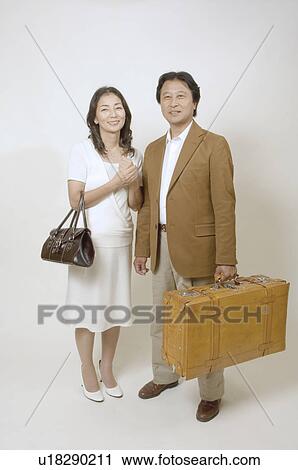 Mature couple standing with suitcase and bag View Large Photo Image Stock Image - Mature couple standing with suitcase and bag. Fotosearch