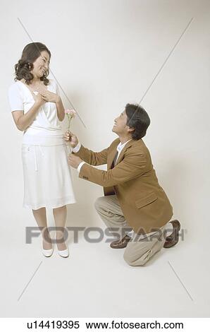 Mature man giving flowers to mature woman View Large Photo Image Stock Photography - Mature man giving flowers to mature woman. Fotosearch