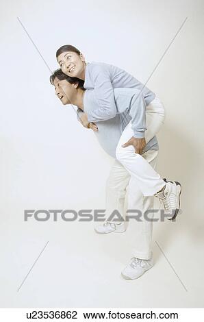 Stock Image - Mature man giving mature woman piggyback. Fotosearch