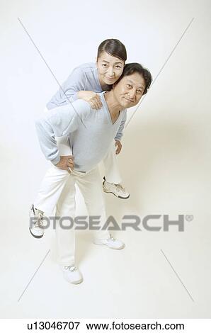 Mature man giving mature woman piggyback View Large Photo Image Stock Photo - Mature man giving mature woman piggyback. Fotosearch