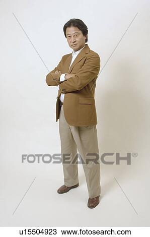 Mature man standing with his arms crossed View Large Photo Image Stock Image - Mature man standing with his arms crossed. Fotosearch